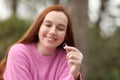 Woman with long red hair smiles while looking at her engagement ring Royalty Free Stock Photo