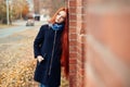 Woman with long red hair walks in autumn on the street. Mysterious dreamy look and the image of the girl. Redhead woman walking Royalty Free Stock Photo