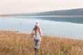 Woman in long soft grasses by lake Country Life