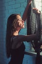 Woman with long wet or oily hair. Woman in black bodysuit at window. Beauty girl with natural look and healthy skin