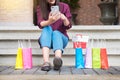 Woman look at mobile phone with paperbags in the mall while enjoying a day shopping. Royalty Free Stock Photo