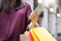Woman look at mobile phone with paperbags in the mall while enjoying a day shopping Royalty Free Stock Photo
