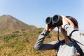 Woman look though binocular when going hiking