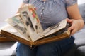 Woman looking through an album with old photographs, concept of memories of youth, childhood, remembering her life, relatives, Royalty Free Stock Photo