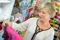 Woman looking appreciatively at knitted garment
