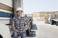 Woman looking away while standing by flatbed truck in timber yard