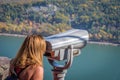 Woman looking through binoculars at scenic overlook in autumn Royalty Free Stock Photo