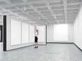 Woman is looking at a blank picture in an art gallery
