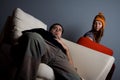 Woman looking on bored man sitting on couch