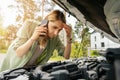 Woman looking at broken car engine and talking on the phone Royalty Free Stock Photo