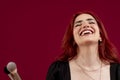 Woman smiling while holding makeup brushes standing against an isolated background. Royalty Free Stock Photo