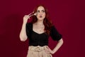 Woman looking at camera while holding makeup brushes standing against an isolated background. Royalty Free Stock Photo