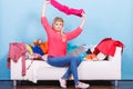 Woman looking through clothes on messy couch Royalty Free Stock Photo