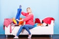 Woman looking through clothes on messy couch Royalty Free Stock Photo