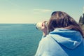 Woman looking through coin operated binoculars at seaside. Royalty Free Stock Photo