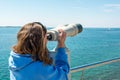 Woman looking through coin operated binoculars at seaside. Royalty Free Stock Photo