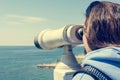 Woman looking through coin operated binoculars at seaside. Royalty Free Stock Photo