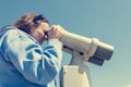 Woman looking through coin operated binoculars at seaside. Royalty Free Stock Photo