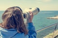 Woman looking through coin operated binoculars at seaside. Royalty Free Stock Photo