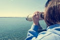 Woman looking through coin operated binoculars at seaside. Royalty Free Stock Photo