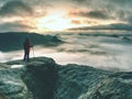 Woman looking at daybreak horizon from sharp cliff Royalty Free Stock Photo