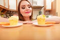 Woman looking at delicious sweet cake. Gluttony.