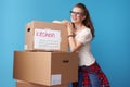 Woman looking into distance standing next to cardboard boxes Royalty Free Stock Photo