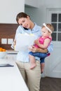 Woman looking in documents while carrying baby girl Royalty Free Stock Photo