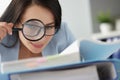 Woman looking at documents in folder through magnifying glass Royalty Free Stock Photo