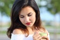 Woman looking down holding a coffee cup outdoors