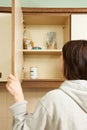 Woman Looking In Empty Food Cupboards