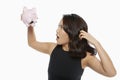 Woman looking into an empty piggy bank Royalty Free Stock Photo