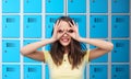 woman looking through finger glasses over lockers Royalty Free Stock Photo