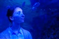 Woman looking at fish in large public aquarium tank at oceanarium Royalty Free Stock Photo