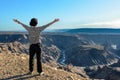 Woman looking at the Fish River Canyon in Namibia from the viewpoint, girl tourist travels Africa Royalty Free Stock Photo