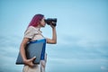 Woman looking forward in binoculars. Lady holding laptop and folder. Goal setting and new horizons concept, copy space