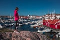 Woman looking at harbour with boats in village of Skaerhamn on the archipelago island of TjÃ¶rn in the west of Sweden