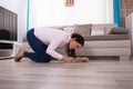 Woman Looking At Hardwood Floor Through Magnifying Glass