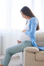 Woman looking at her belly on the sofa Royalty Free Stock Photo