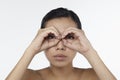 Woman looking through her hands as binoculars. Conceptual image