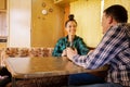 Woman looking at her lover and smiling stands at table in retro camper