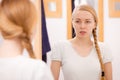 Woman looking at her reflection in mirror