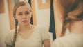 Woman looking at her reflection in mirror