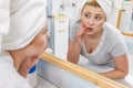 Woman looking at her reflection in mirror