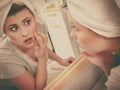 Woman looking at her reflection in mirror