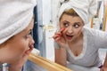 Woman looking at her reflection in mirror
