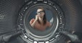 Woman looking into her smelly washing machine Royalty Free Stock Photo