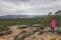 A woman looking at incoming storm on sandstone cliff of Reeds Lookout in Grampians National Park, Victoria, Australia.