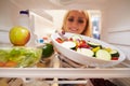 Woman Looking Inside Fridge Full Of Food And Choosing Salad Royalty Free Stock Photo