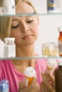 Woman Looking in Medicine Cabinet Royalty Free Stock Photo